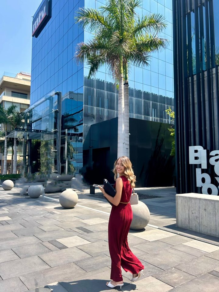Mayssa Murr in a burgundy jumpsuit walking past the MTV building